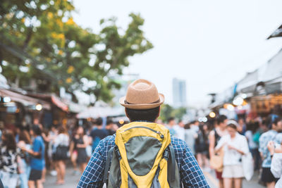 Man wearing hat while standing at market in city