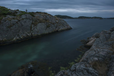 Rock formations in sea against sky