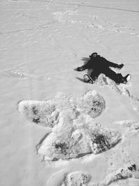 High angle view of child making angel on snowfield