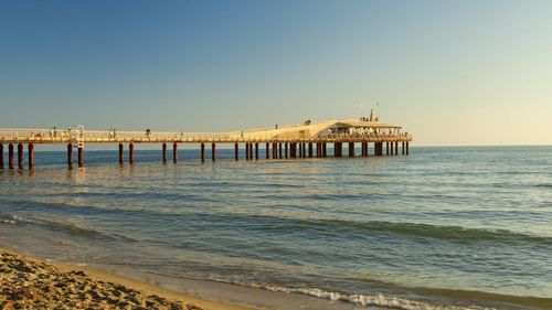 Pier on sea against clear sky