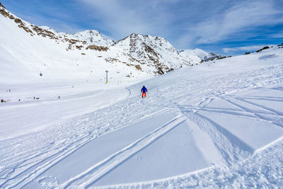 Person skiing on snowcapped mountain against sky