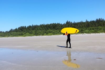 Full length of person standing on a beach during summertime 