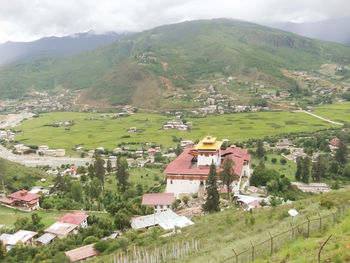 Scenic view of village by mountains against sky