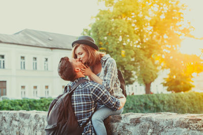 Young couple kissing against plants