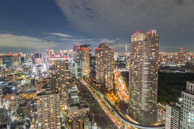 Aerial view of illuminated buildings in city against sky