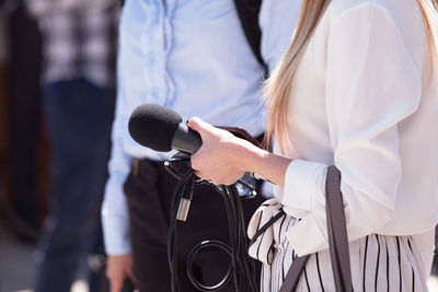 Side view of woman holding microphone