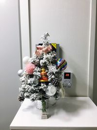 Flower vase on table against white wall