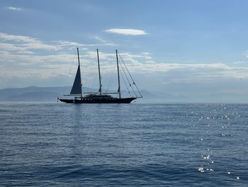 Sailboat sailing on sea against sky