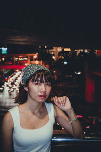 Portrait of young woman looking down at night