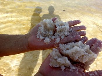 Close-up of hand holding ice cream on beach