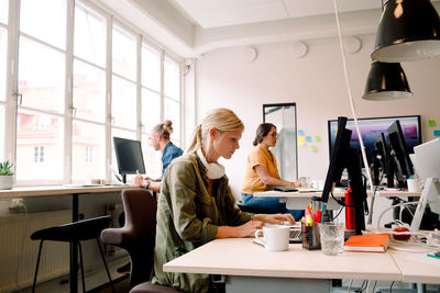 Male and female coworkers working at desks in office