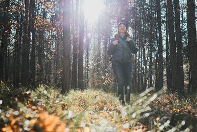 Woman enjoying hike on sunny vacation day. female walking through forest. spending summer vacations