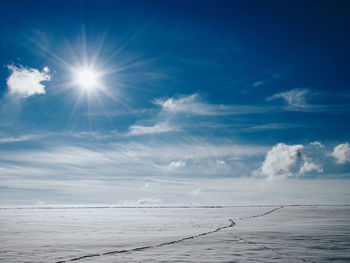 Scenic view of snow covered land against bright sky