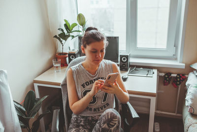 Woman using mobile phone at home