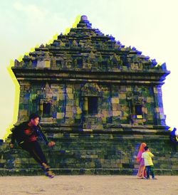 People at temple against building