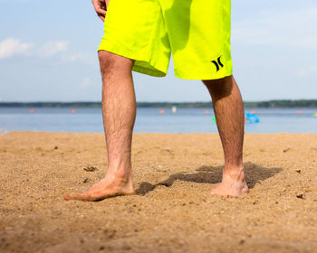 Low section of woman standing on beach