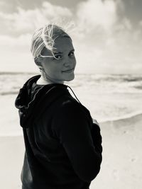 Girl standing at beach against sky