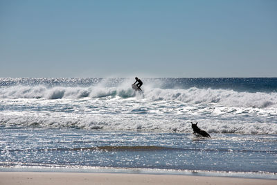 Man surfing in sea against clear sky