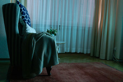 Blanket and cushions on chair at home