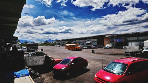 Cars on road in city against sky