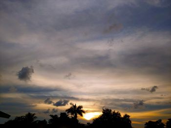 Low angle view of silhouette trees against dramatic sky