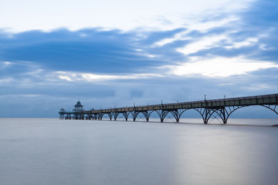 View of bridge over sea against cloudy sky