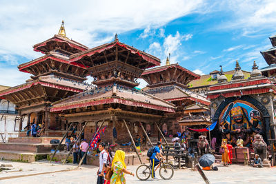 Group of people outside temple against building