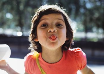 Close-up portrait of cute girl sticking out tongue