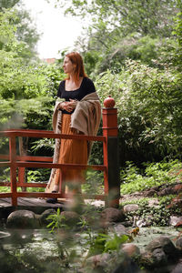 Happy ginger hair woman in well-groomed park or garden. freedom and healthy way of life. female in