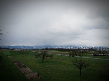 Scenic view of grassy field against cloudy sky