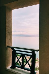 Chair and table by sea against sky