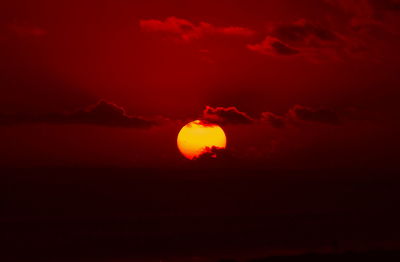 Silhouette of red light against sky during sunset