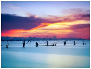 Scenic view of sea against dramatic sky during sunset