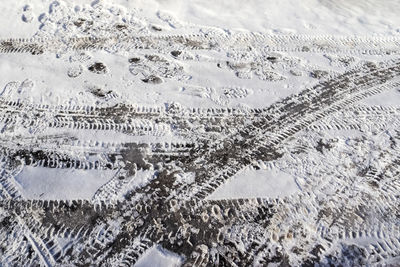 High angle view of tire tracks on snow covered land