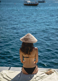 Rear view of woman in hat against sea