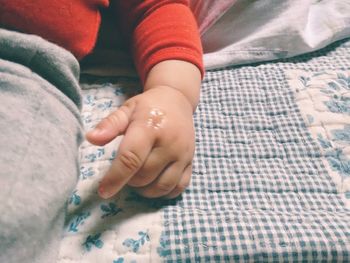 Close-up of baby hand on bed