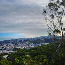 View of cityscape against cloudy sky