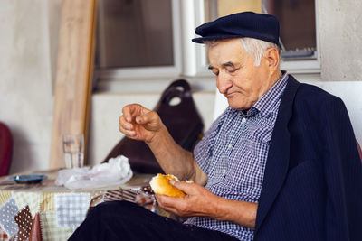 Midsection of man holding drink sitting on table