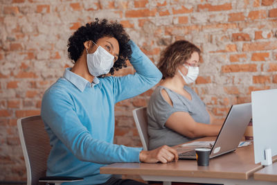 Business people wearing mask while working at office