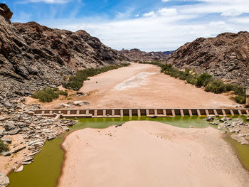 View of dam on mountain road against sky