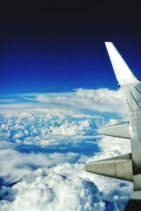 Aerial view of airplane wing over clouds