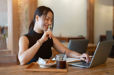 Young woman using laptop at table