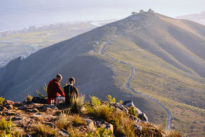 Rear view of man relaxing on mountain