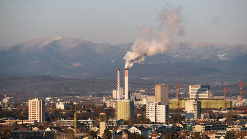 Smoke emitting from chimney against sky