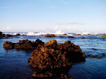 Scenic view of rocks on beach against sky