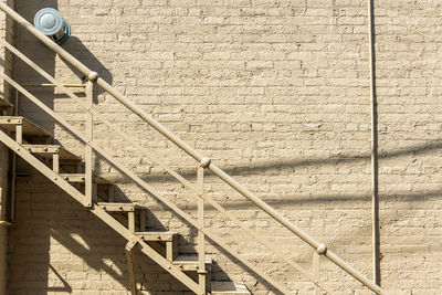 Low angle view of steps by wall