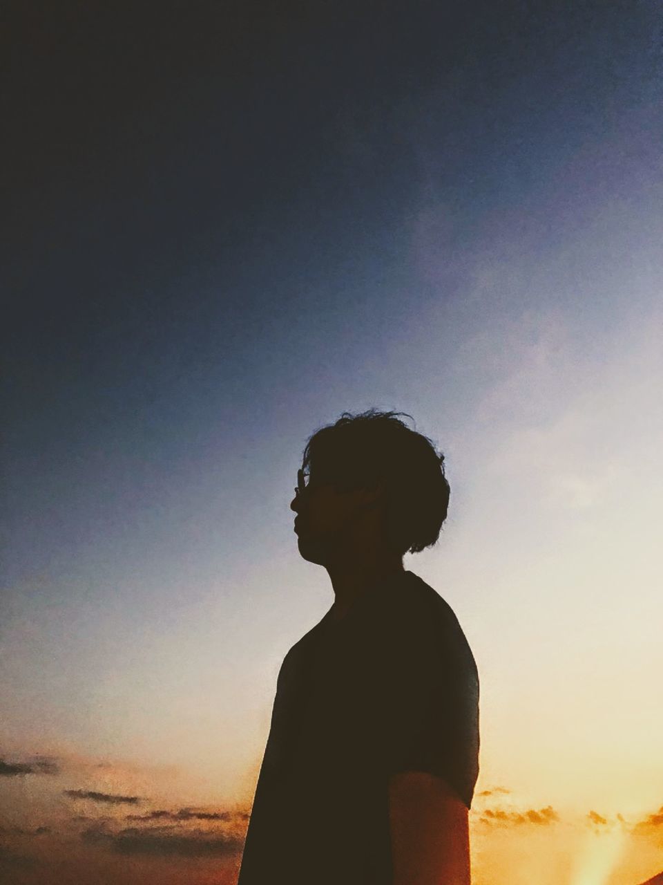 sky, one person, horizon, sunset, backlighting, sunlight, silhouette, nature, adult, land, standing, copy space, leisure activity, cloud, lifestyles, child, waist up, tranquility, dusk, sun, beauty in nature, outdoors, men, childhood, back lit, women, looking, emotion, vacation, beach, person, evening