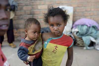 Madagascar, fianarantsoa, homeless litle girl carrying todler
