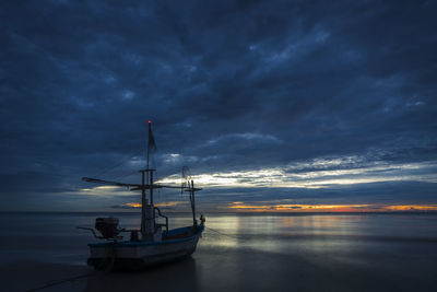 Sailboat in sea against sky at sunset