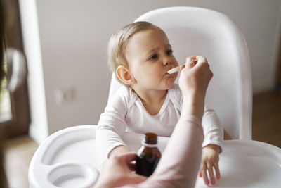 Portrait of cute baby girl sitting at home